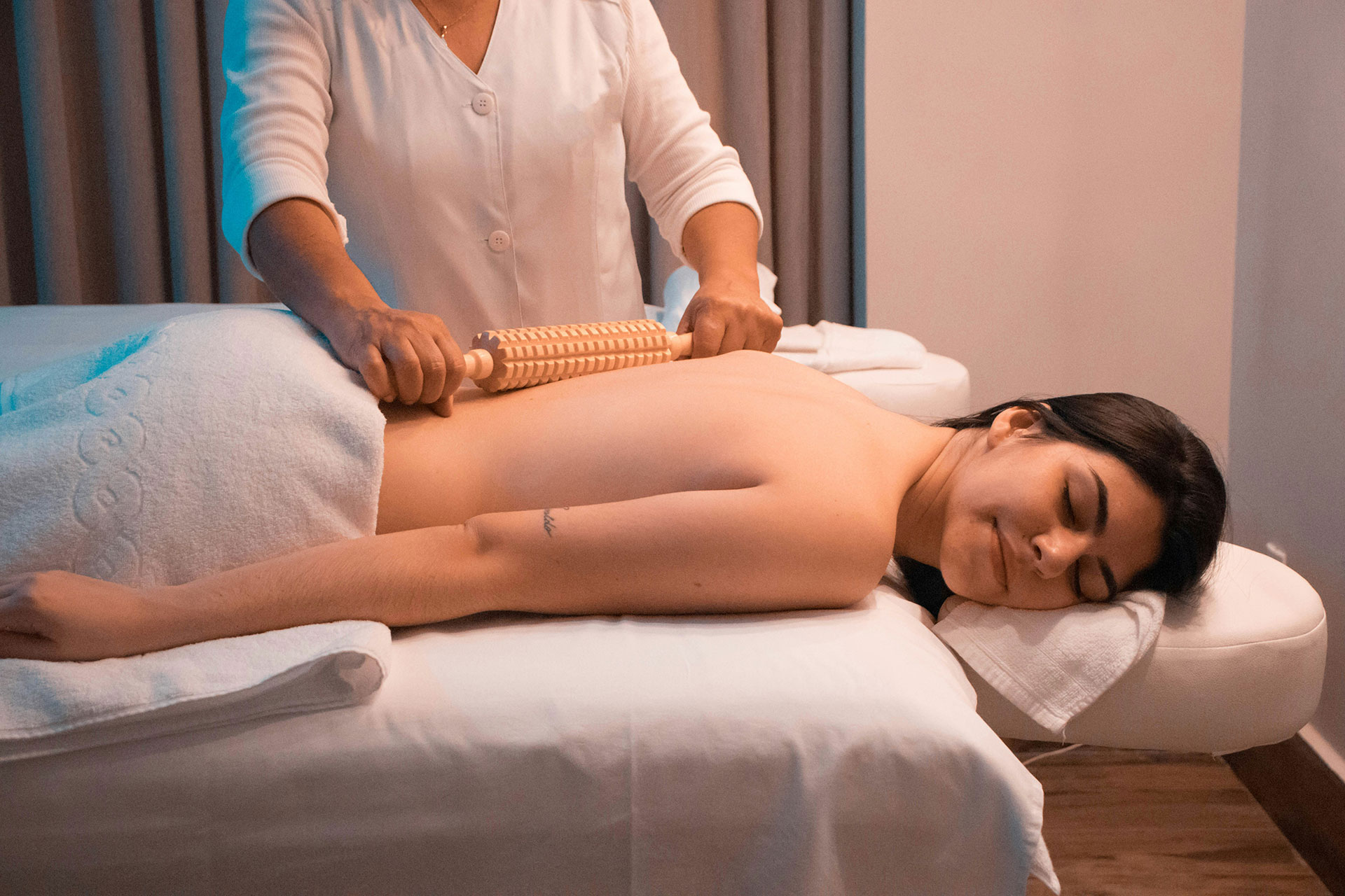 Massaggio corpo con rullo in legno su lettino